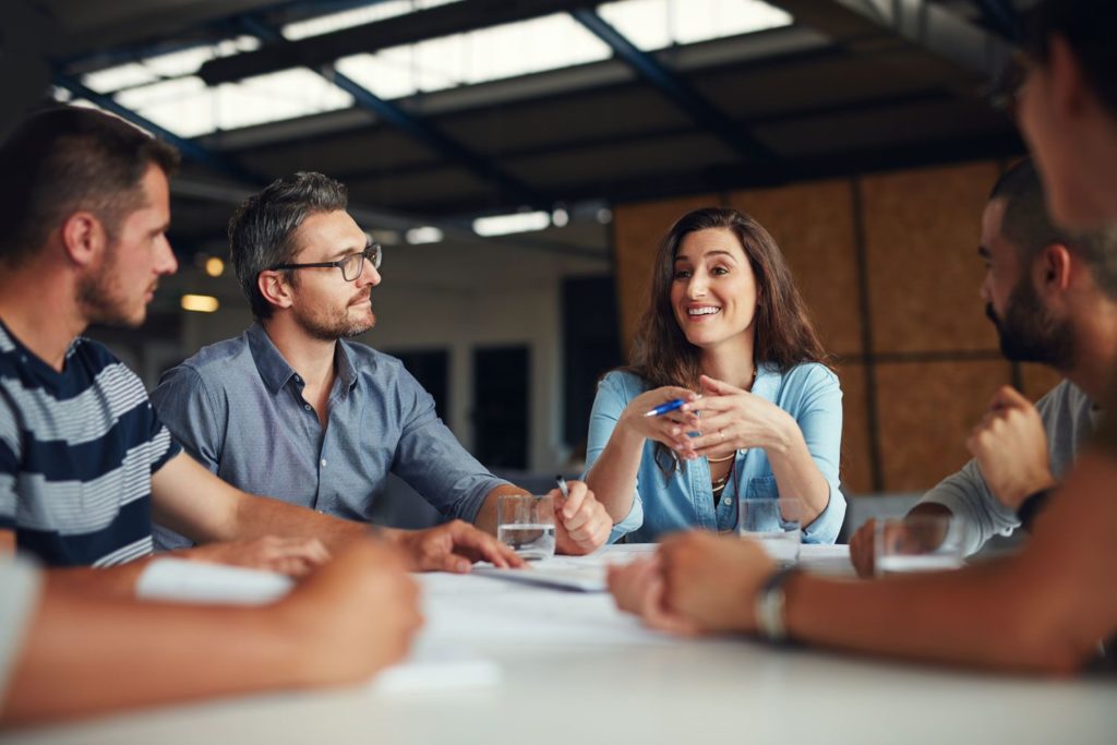 photo of a group of professionals sitting around a table talking